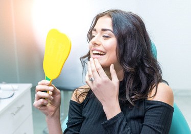 a person smiling after receiving a dental bridge in Garland 