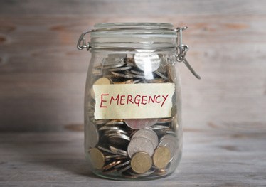 Coins in a jar labeled “Emergency”