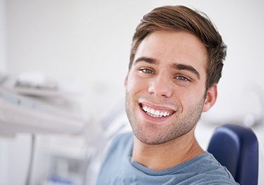 Smiling young man in dental chair