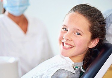 Smiling young girl in dental chair