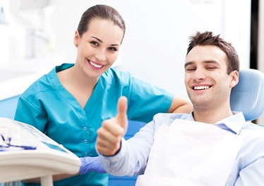 Man at dentist giving thumbs up