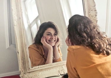 Woman looking at smile in mirror