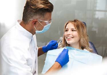 young woman smiling at her dentist