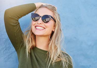woman in sunglasses smiling brightly