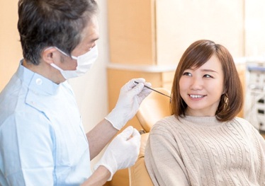 woman in the dental chair smiling at her dentist