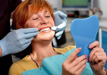 patient admiring her smile in a mirror