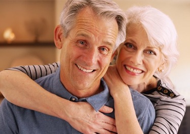 An older couple hugging and smiling.