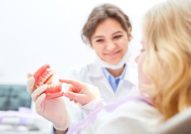 Garland dentist discussing dentures with patient missing teeth