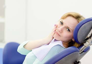 Woman with a dental emergency in Garland visiting her dentist