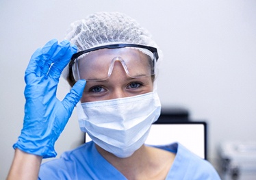 Smiling dental team member wearing personal protective equipment