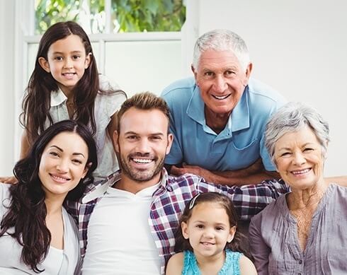 Three generations of family smiling while sitting on couch