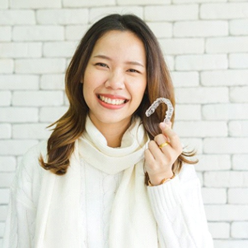 woman holding clear aligner 