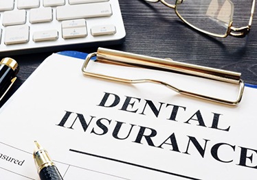 dental insurance form on a blue clipboard 