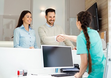 dental team member shaking a patient’s hand 