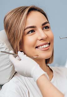 Woman smiling while getting a dental checkup in Murphy, TX