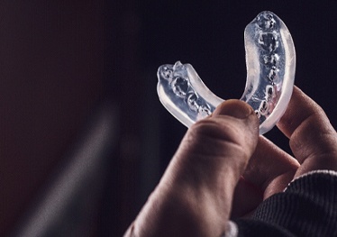 person holding mouthguard