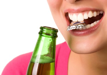 woman opening bottle with teeth