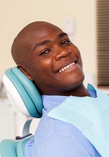 man smiling while getting a dental checkup