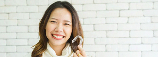 woman holding clear aligner