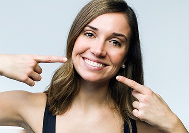 Woman pointing to her smile