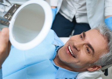 Man admiring his smile after paying for take-home teeth whitening in Garland 