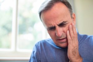 Man in blue shirt having a dental emergency