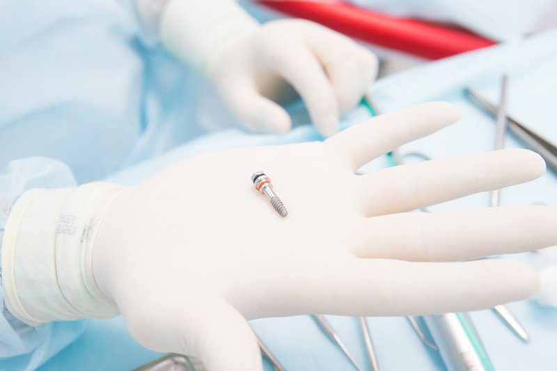 Close-up of dentist holding a dental implant