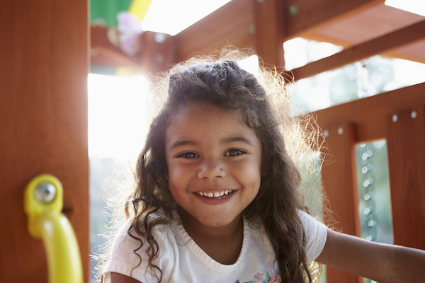 young girl playing on playgym outdoors