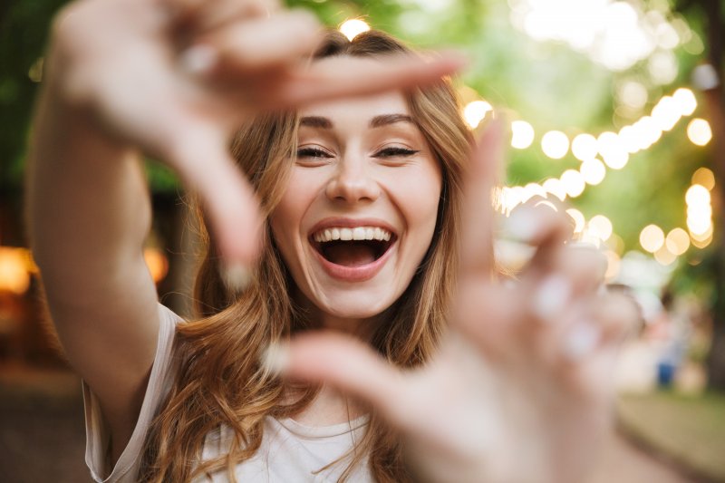 woman smiling after getting cosmetic dental treatments in Garland