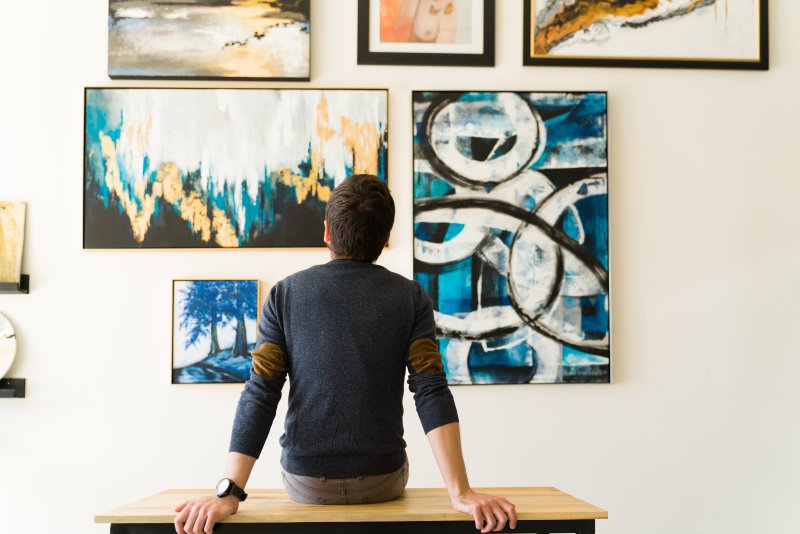 someone looking at a painting on a wall