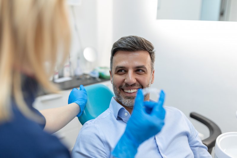 A man smiling at his dentist while talking about cosmetic dentistry options